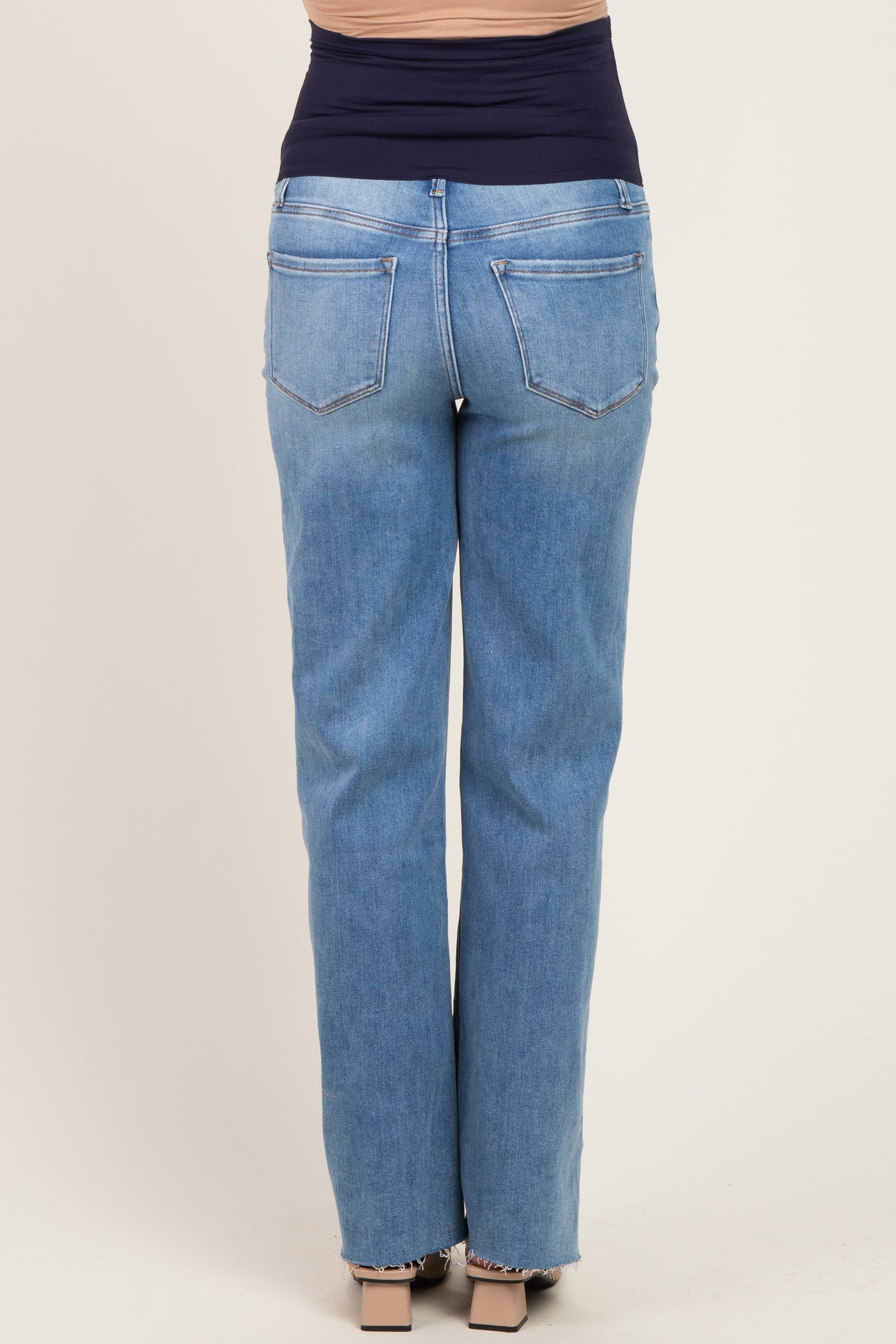 woman wearing light blue maternity jeans, showing the back view with a stretchy waistband