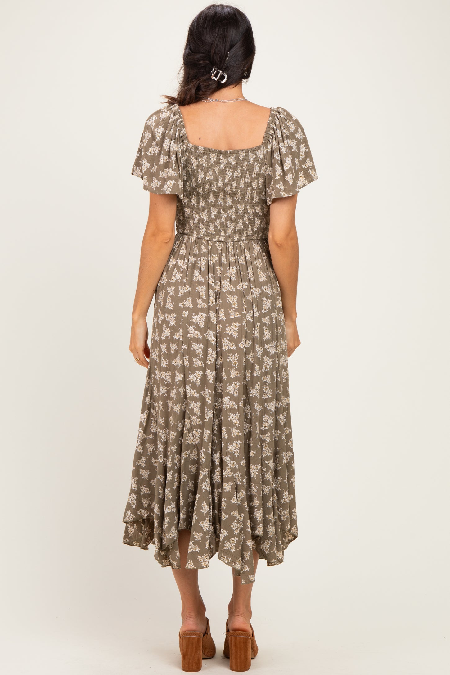 woman wearing a brown floral maxi dress with short sleeves and a smocked bodice, shown from the back