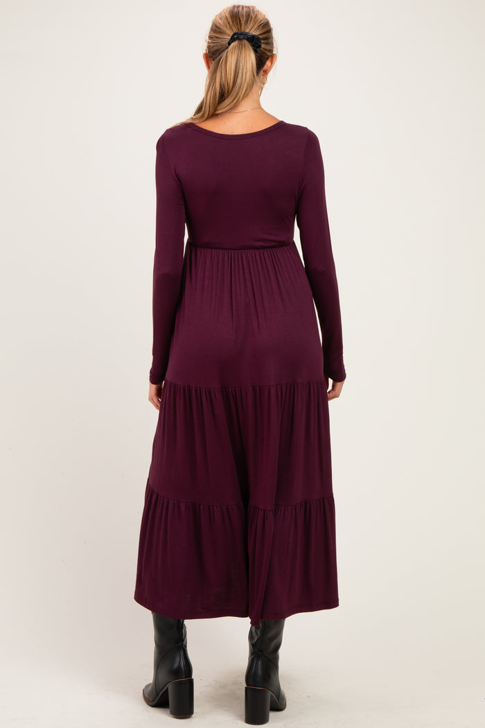 woman wearing a long sleeve burgundy maternity dress with tiered hemline and back view displayed