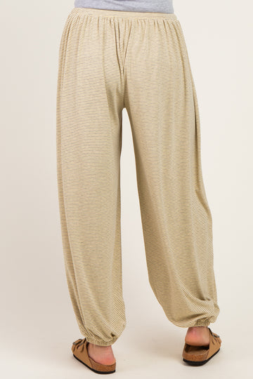 woman wearing beige striped maternity harem pants with an elastic waistband and tapered cuffs