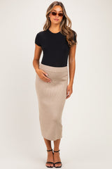 woman wearing a black short sleeve maternity bodysuit and a beige ribbed midi skirt, baby bump visible