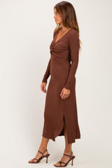 woman wearing a chocolate brown long sleeve midi dress with a knot detail at the front and side slit, styled with strappy heels