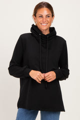 woman wearing a black long sleeve hoodie with a cowl neck and drawstring, smiling at the camera