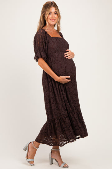 woman wearing a brown lace maternity maxi dress and holding her baby bump