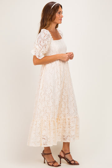 woman wearing a cream lace midi dress with puff sleeves and a ruffled hem