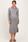 woman wearing a grey maternity sweater dress with a zip collar and side slit, showcasing her baby bump