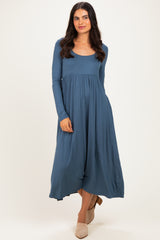 woman wearing a long sleeve blue maxi dress with a scoop neckline and side pockets