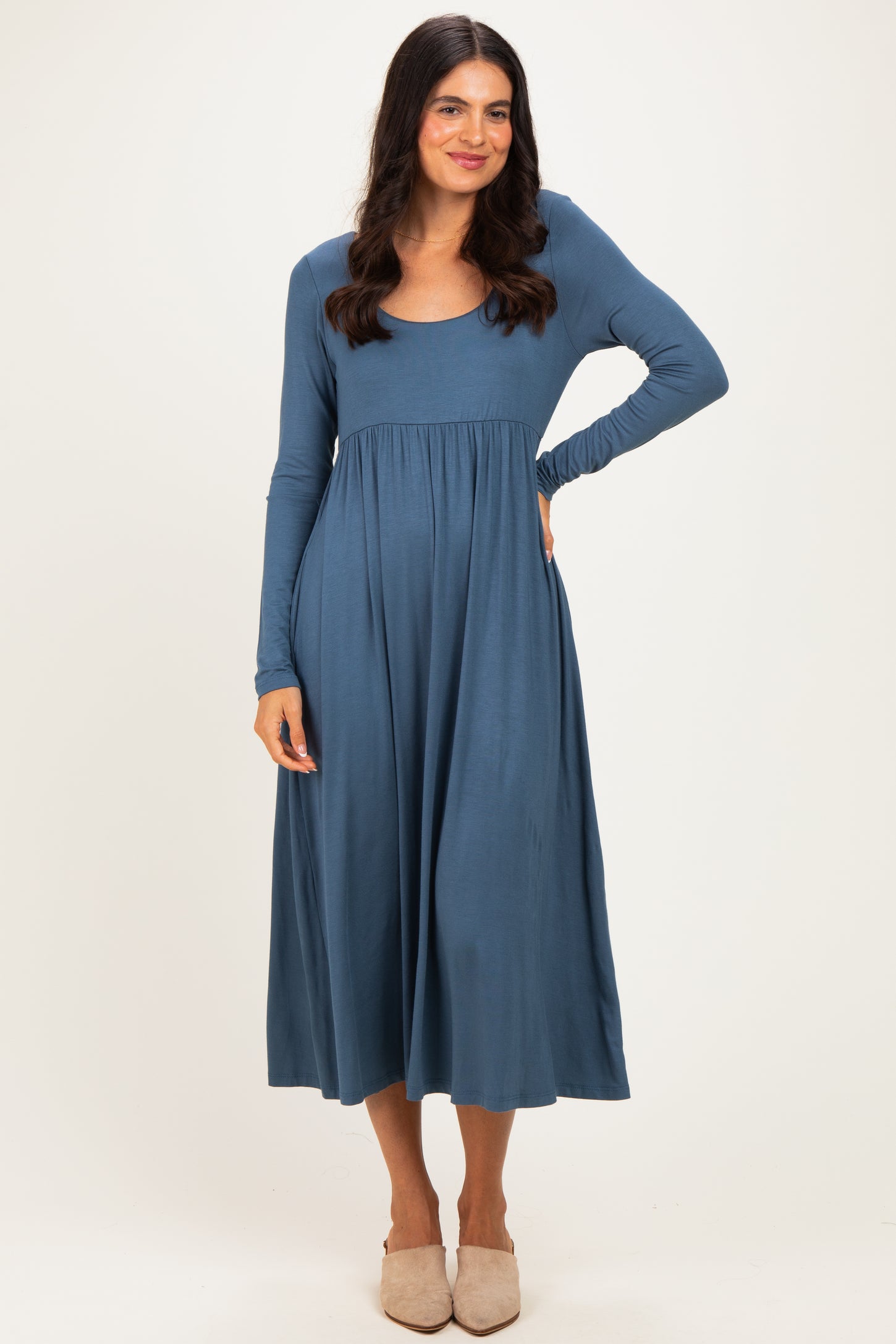woman wearing a blue long sleeve midi dress with a scoop neckline and a gathered waistline.