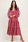 woman wearing a rose pink long sleeve tiered maxi dress with a knotted front detail and a flowy silhouette
