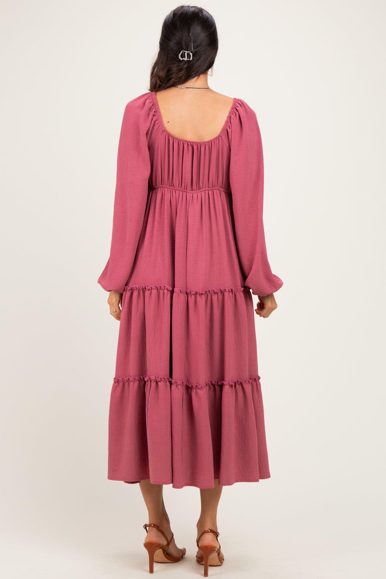 woman wearing a dusty rose long sleeve tiered maxi dress with a square neckline and ruffle detailing