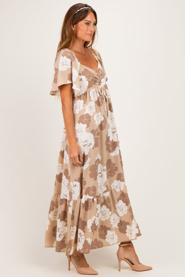 woman wearing a brown and white floral maxi dress with short flutter sleeves and a tie-front detail