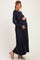woman wearing a navy blue long sleeve maternity dress and holding her baby bump