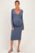 woman wearing a blue long sleeve maternity dress with a v-neckline and a visible baby bump