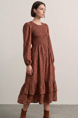 woman wearing a brown floral printed long sleeve dress with ruffle hem and smocked bodice