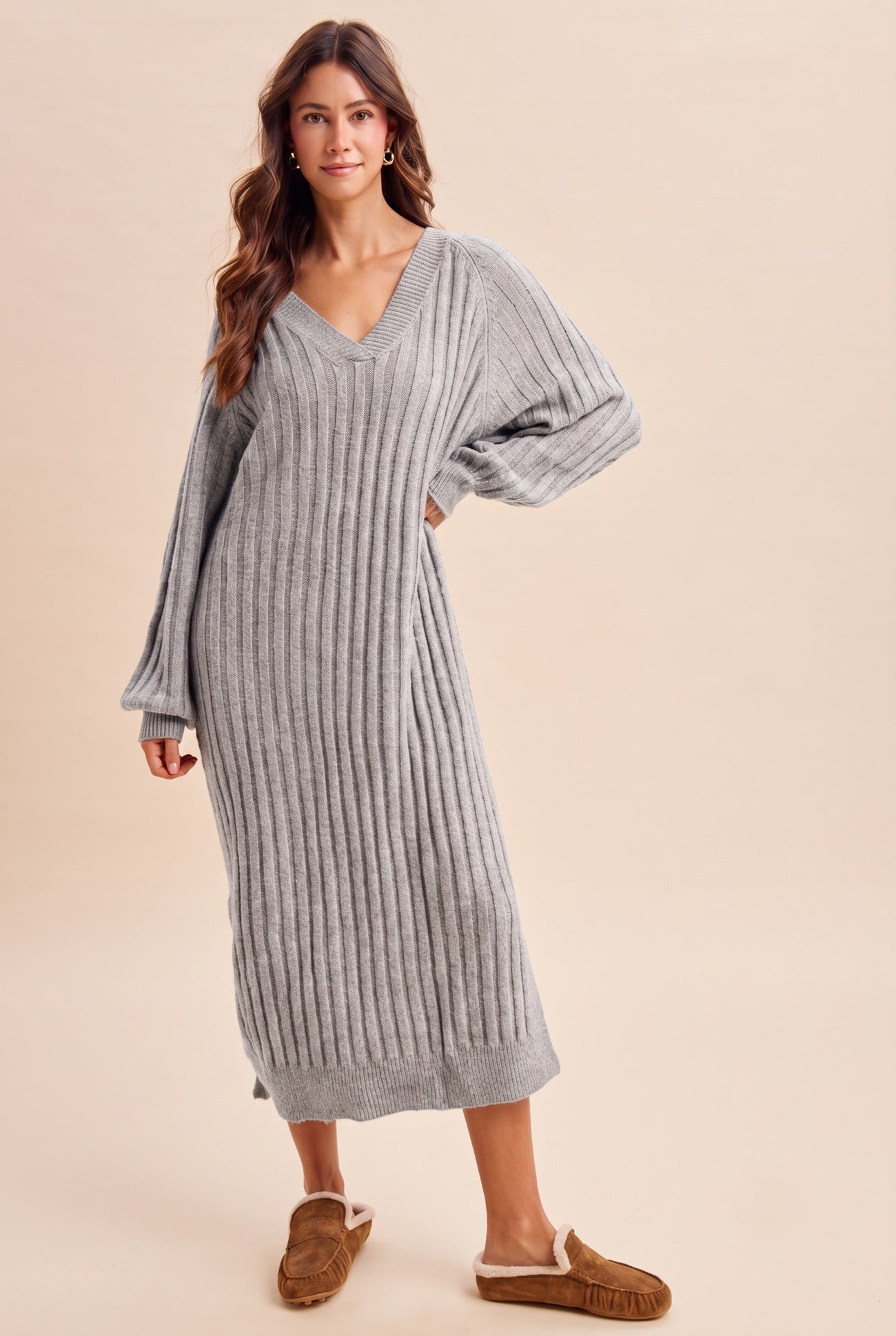 woman wearing a gray ribbed long sleeve sweater dress with a v-neck and relaxed fit