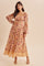 woman wearing a floral print maxi dress with long puff sleeves and a square neckline, standing against a light background