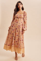 woman wearing a floral print maxi dress with long sleeves and a cinched waist
