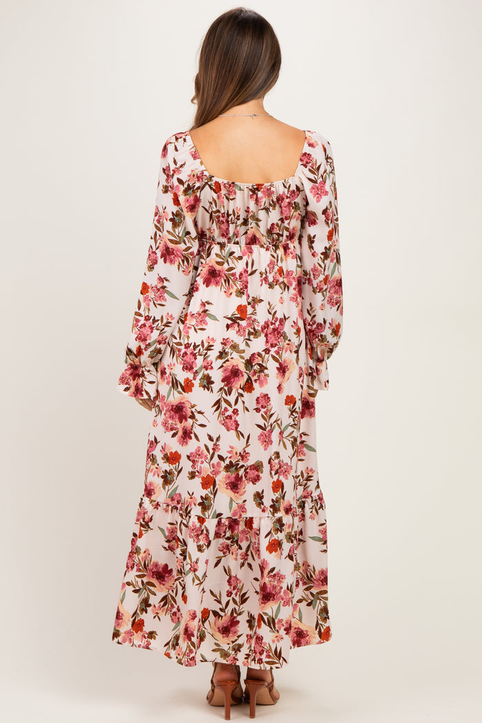 woman wearing a floral long sleeve maternity dress with a flowy fit and visible baby bump