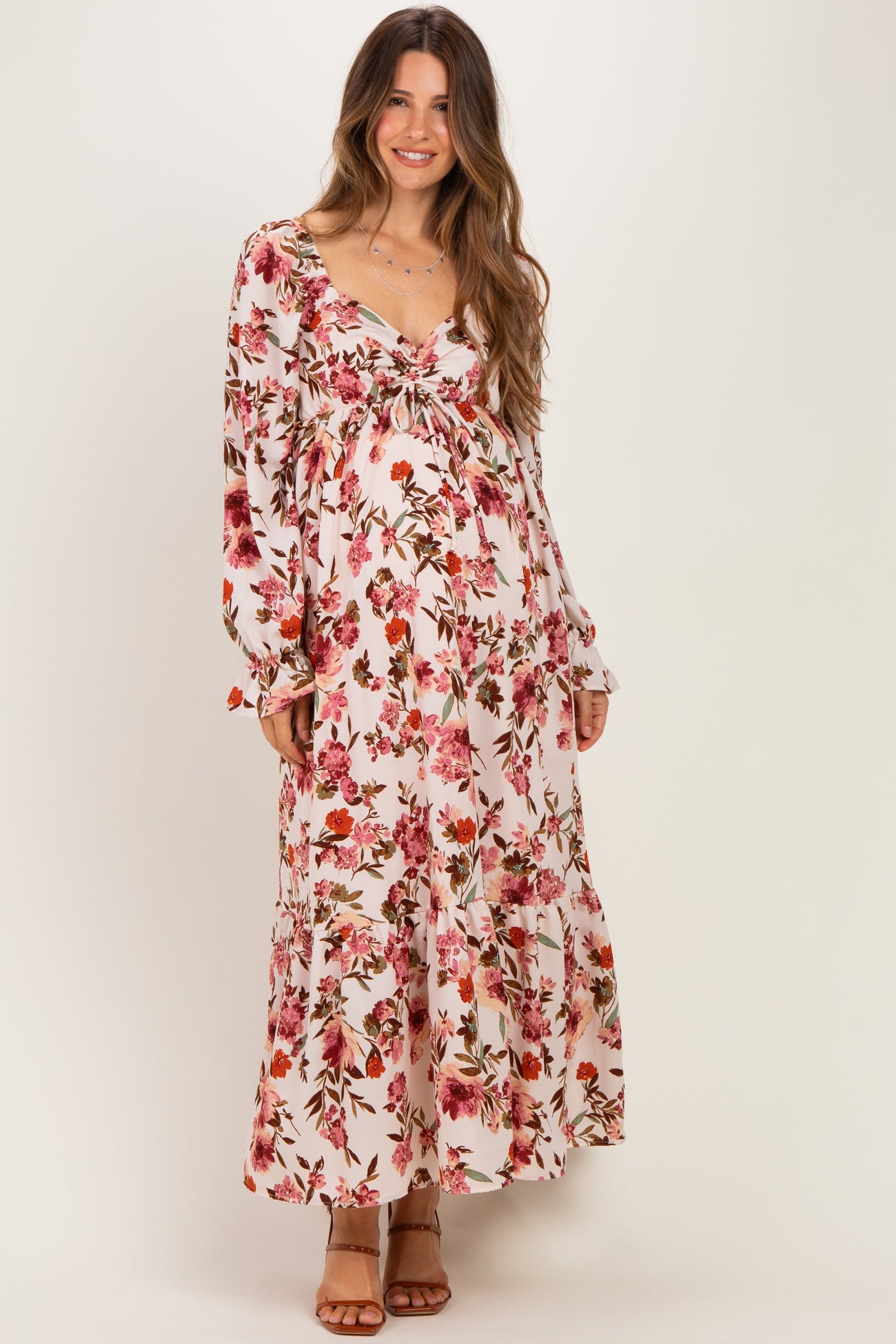 woman wearing a floral long sleeve maternity maxi dress with a baby bump visible
