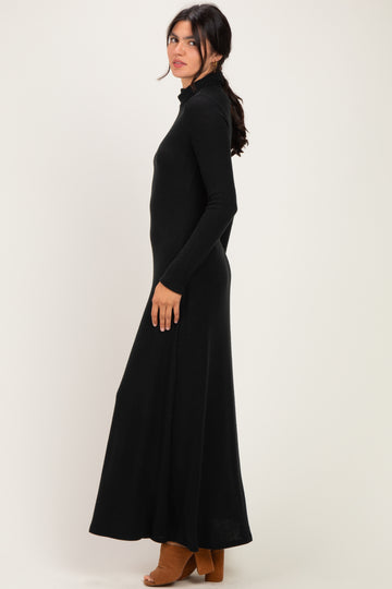 woman wearing a black long sleeve maxi dress with a mock neckline and side slit