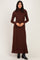 woman wearing a rust long sleeve turtleneck maxi dress with a fitted silhouette and flared hem
