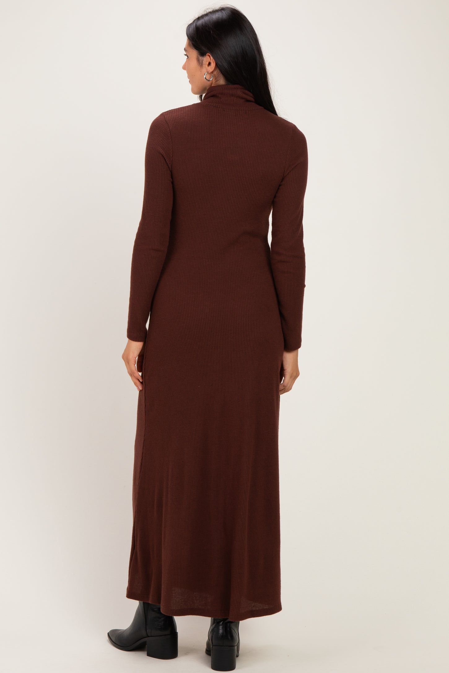woman wearing a long brown ribbed maxi dress with a turtleneck and long sleeves, shown from the back