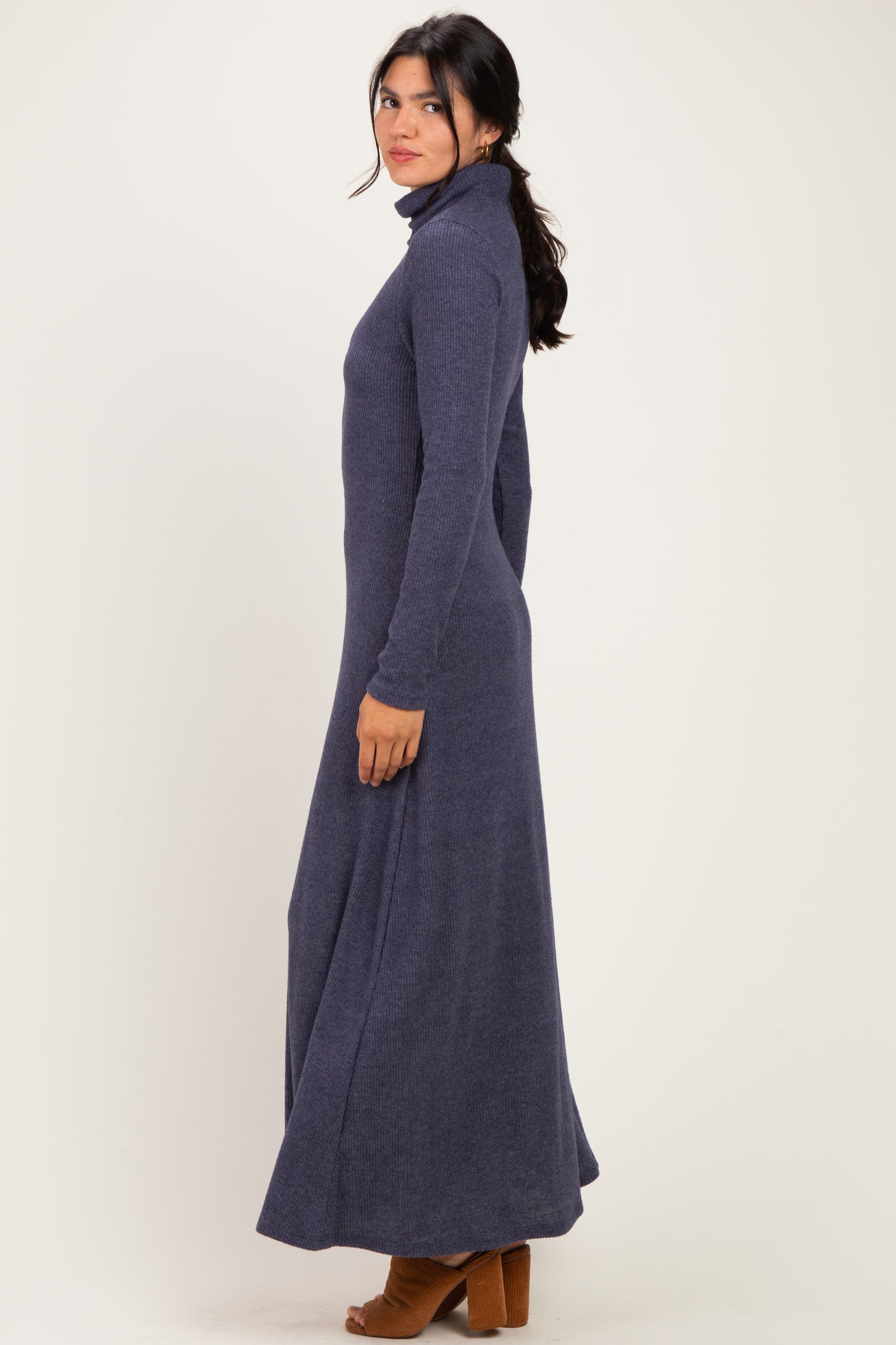 woman wearing a long sleeve navy blue maxi dress with a turtleneck and a fitted silhouette