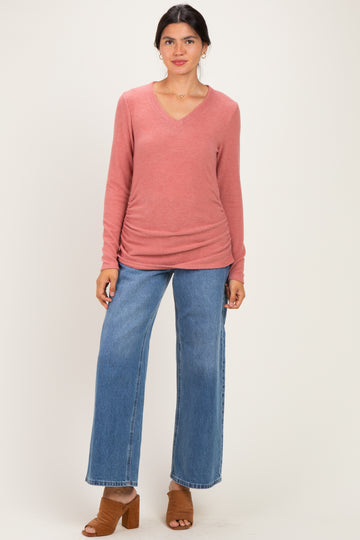 woman wearing a pink long sleeve v-neck sweater paired with blue wide-leg jeans and brown heeled mules