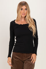 woman wearing a black long sleeve ribbed top with ruffle detailing and a square neckline
