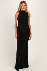 woman wearing a black sleeveless maternity gown with a side wrap detail and a visible baby bump