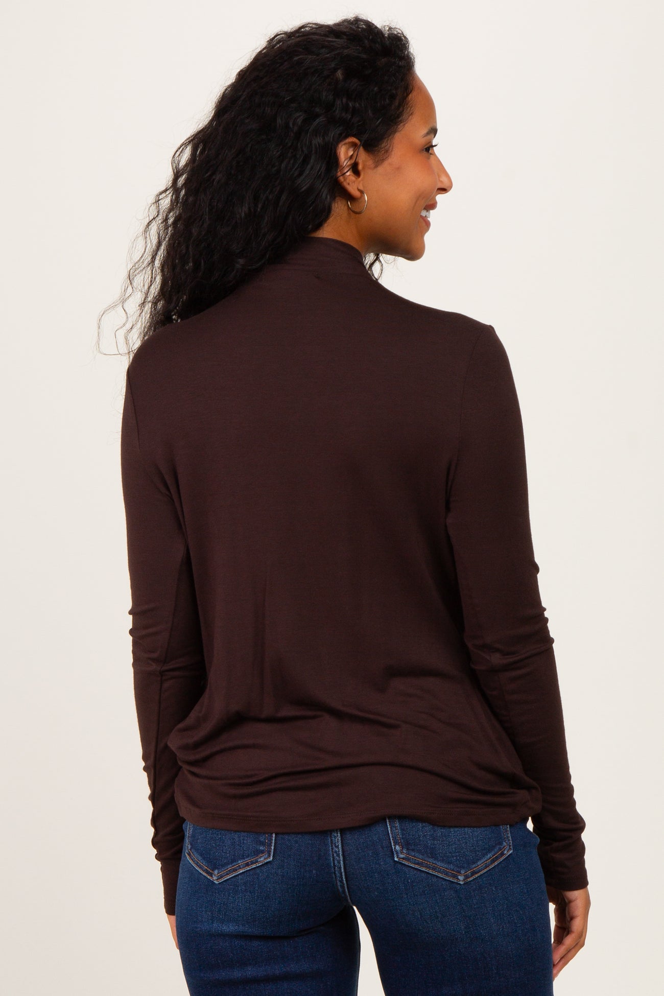 woman wearing a brown long sleeve maternity top, viewed from the back with relaxed fit and rounded hem