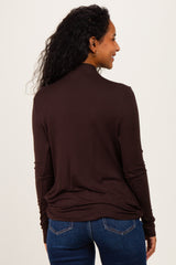 woman wearing a brown long sleeve maternity top, viewed from the back with relaxed fit and rounded hem