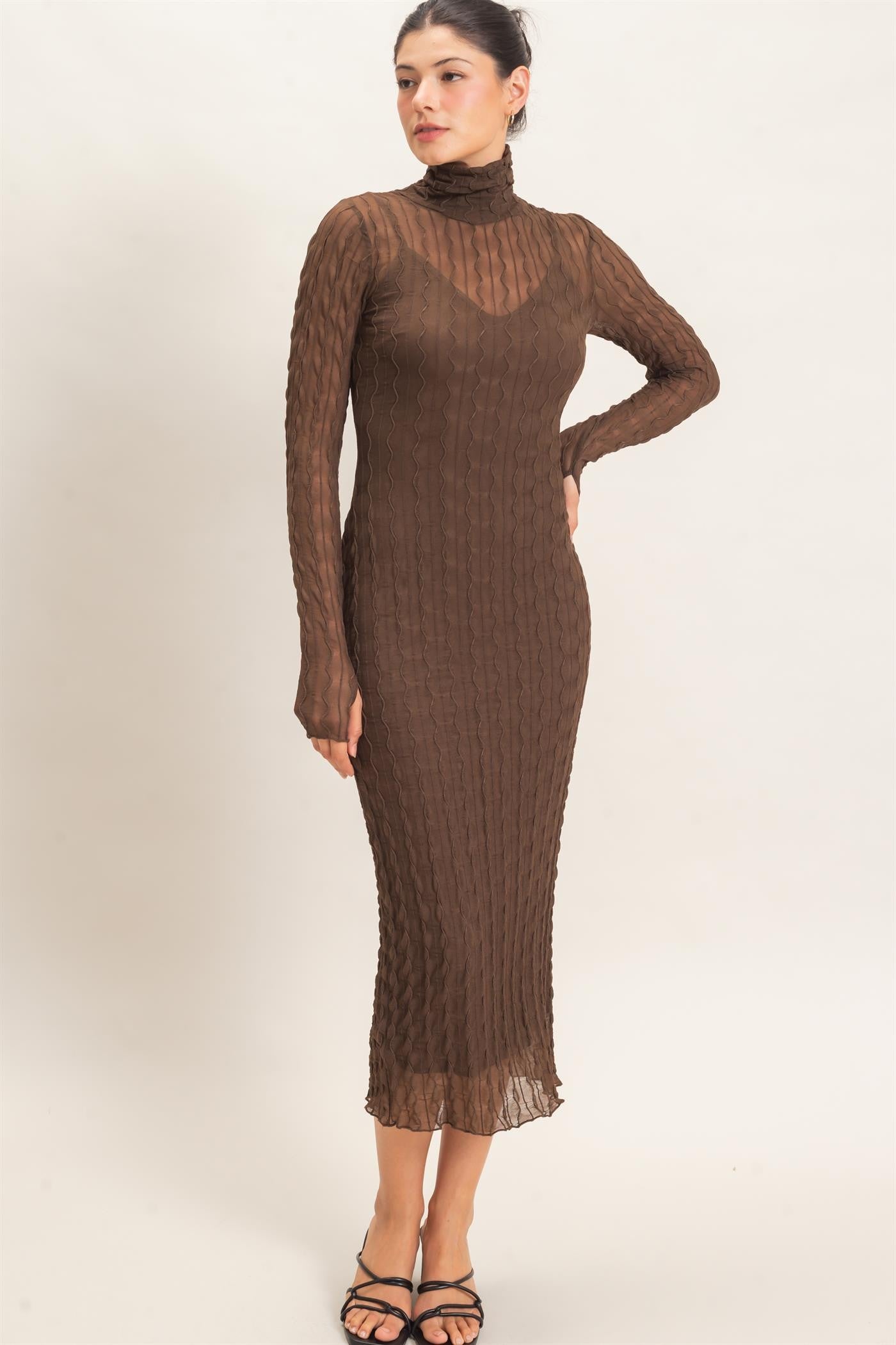 woman wearing a chocolate brown long sleeve fitted dress with a high neckline and textured ribbed design