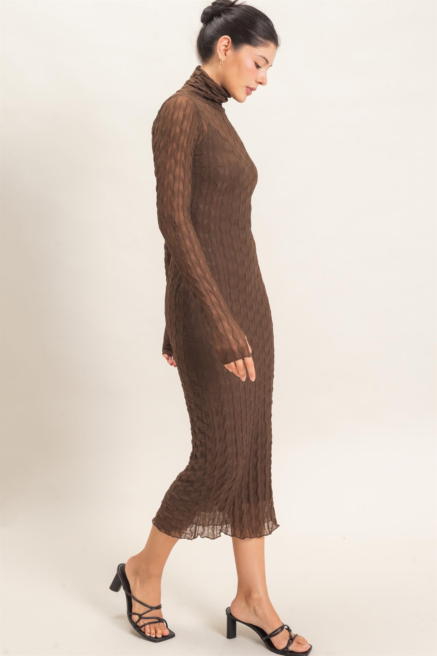 woman wearing a brown ribbed long sleeve dress with a high neckline and a fitted silhouette