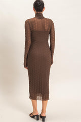 woman wearing a brown ribbed long sleeve midi dress with a high neckline and fitted silhouette