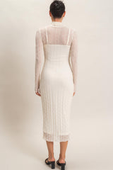 woman wearing a white long sleeve midi dress with a fitted silhouette and textured detailing, viewed from the back