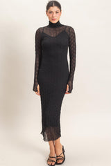 woman wearing a black long sleeve ribbed knit dress with a high neckline and form-fitting silhouette