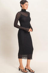 woman wearing a black long sleeve sheer dress with a turtleneck and form-fitting silhouette