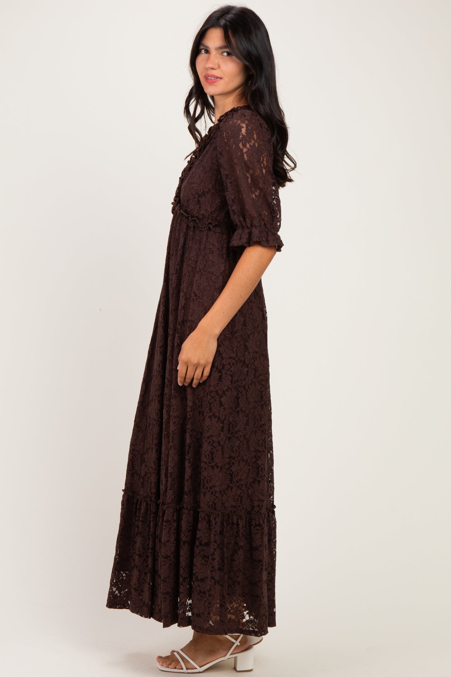 woman wearing a brown lace maxi dress with puff sleeves and a tiered skirt