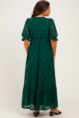 woman wearing a green lace maternity dress with puff sleeves and a tiered skirt, shown from the back
