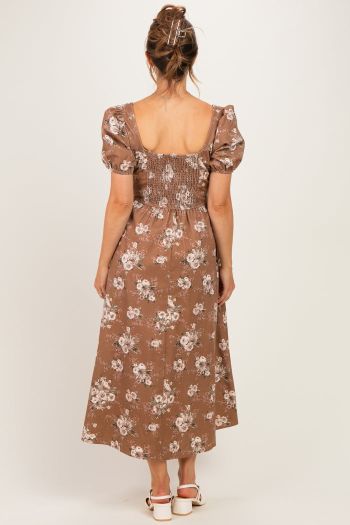 woman wearing a brown floral maternity dress with puff sleeves and smocked back, showing a baby bump