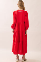 woman wearing a red tiered maxi dress with long sleeves and white trim детали на спине