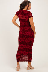 woman wearing a burgundy floral lace maternity dress with short sleeves and a form-fitting silhouette visible from the back