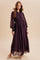 woman wearing a dark purple long sleeve maxi dress with white polka dots and a pleated bodice