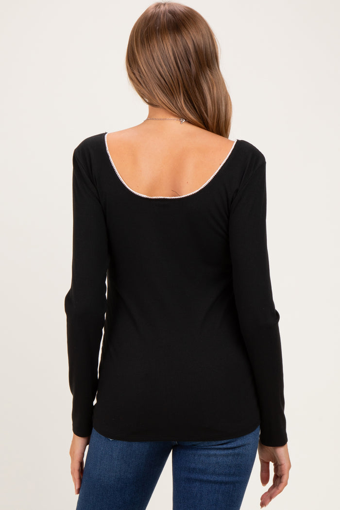 woman wearing a black long sleeve maternity top with a scoop back and stylish ribbed texture