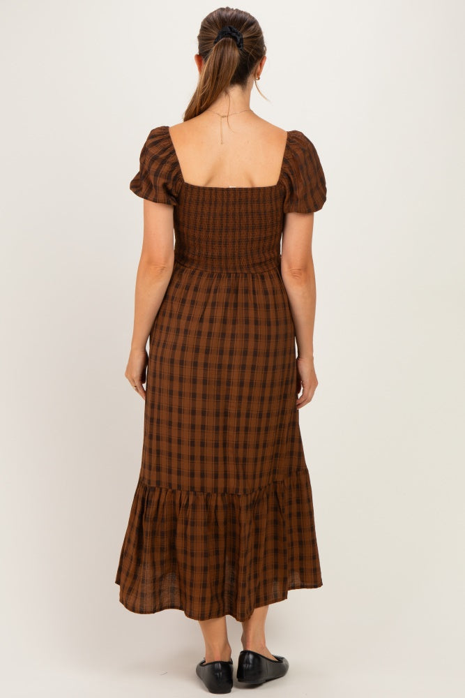 woman wearing a brown plaid maternity dress with puff sleeves and a tiered skirt, showing the back view