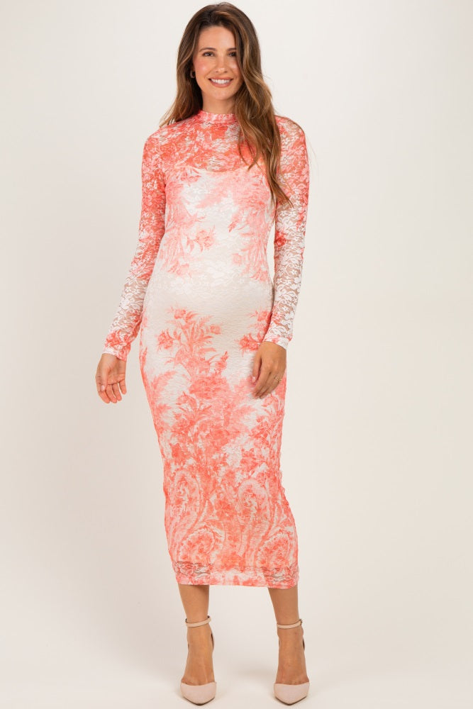 woman wearing a coral and white long sleeve lace maternity dress with intricate floral patterns and a fitted silhouette