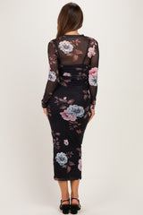 woman wearing a black floral maternity dress with long sleeves and a fitted silhouette, showing her baby bump