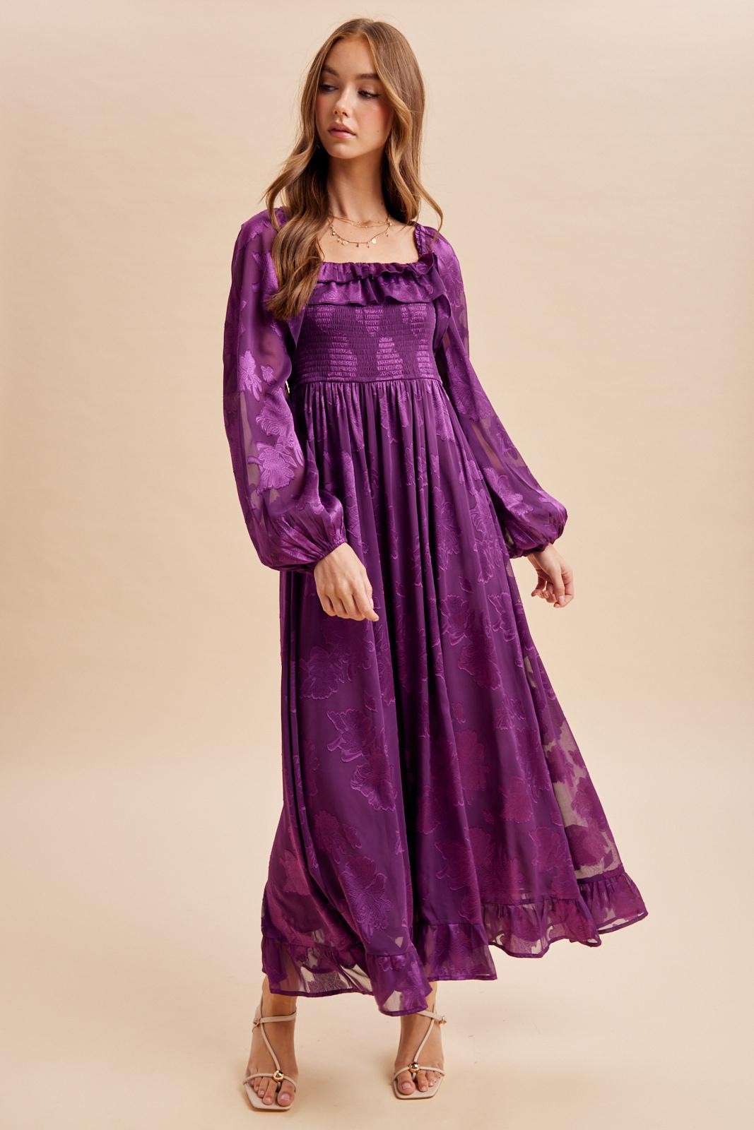 woman wearing a purple floral maxi dress with puff sleeves and a smocked bodice