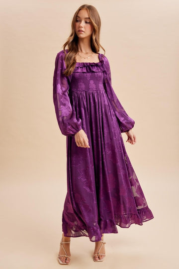 woman wearing a purple floral maxi dress with puff sleeves and a smocked bodice